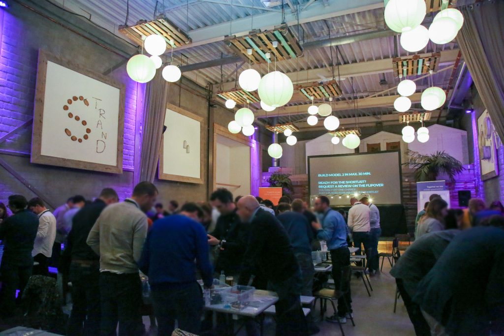 Grote zaal met een groep die meedoet aan een evenement met LEGO® bouwstenen