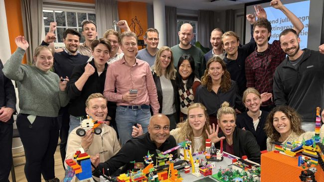 Een groep die net een geweldige Chain Reaction van LEGO® bouwstenen gebouwd heeft